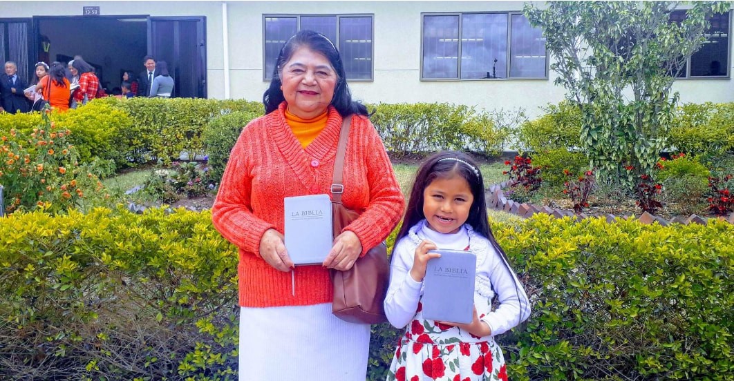 Grandmother and child holding Bibles